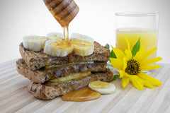 Honey on banana sandwich with glass of orange juice