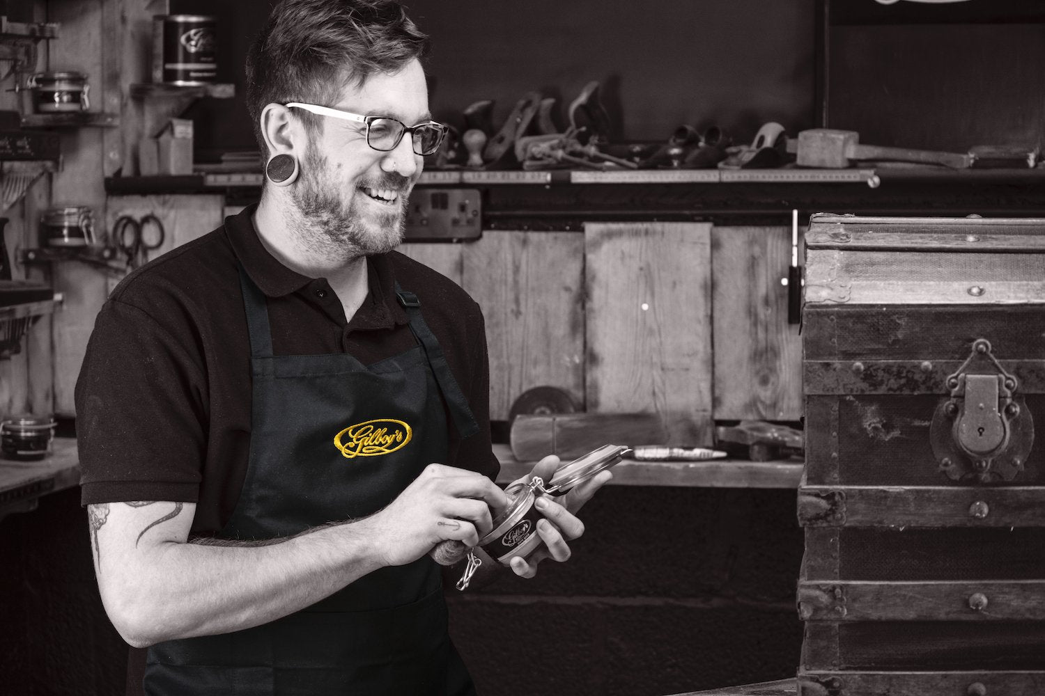 restorer Archie wearing a black bib apron