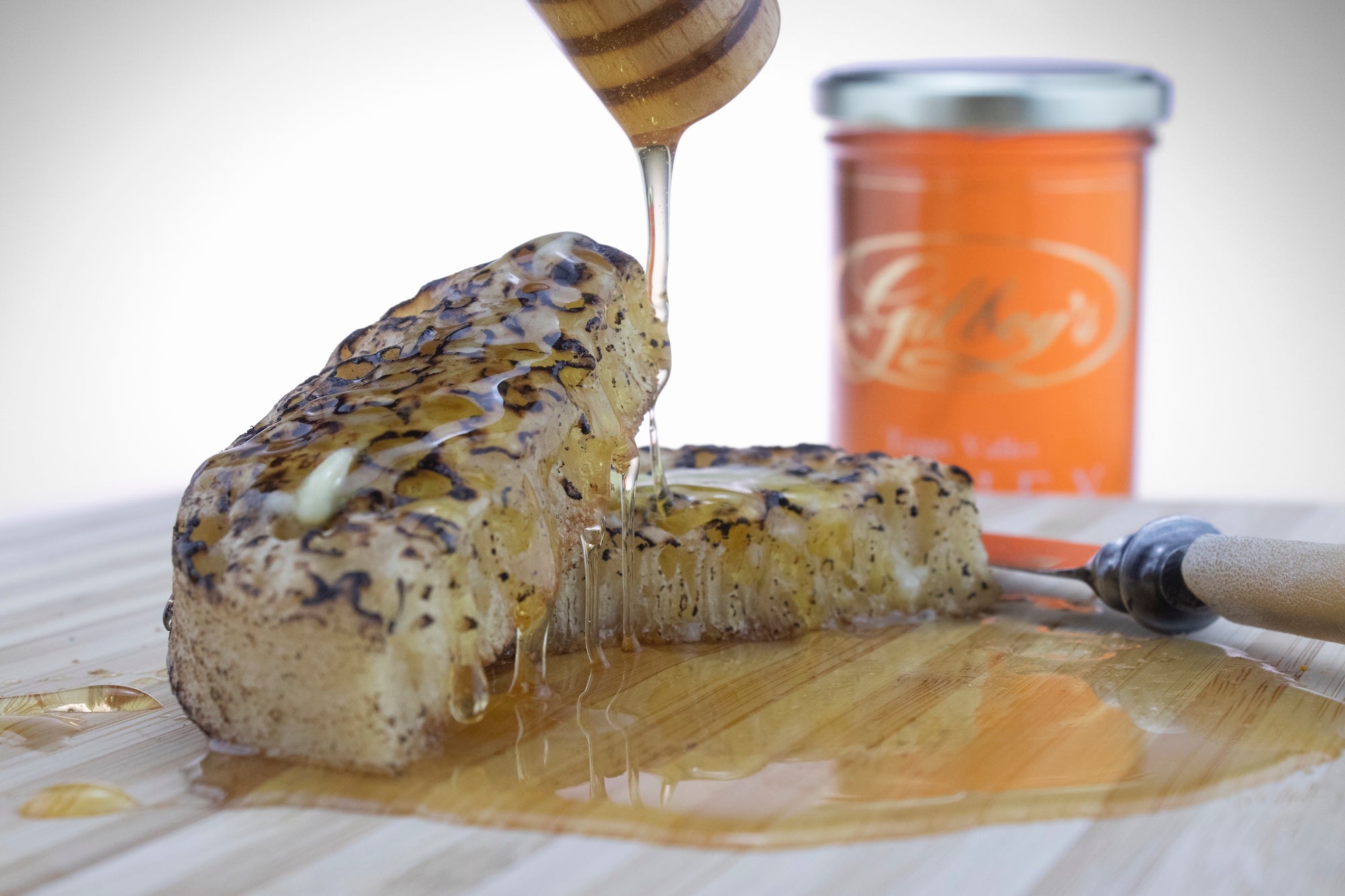 Honey being drizzled on freshly baked crumpets
